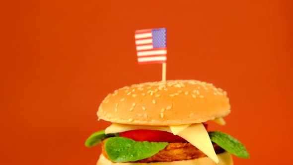 Hamburger Day.burger with decorative american flag on a  brown background