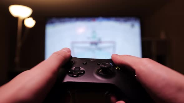 Man using controller playing hockey. Concept of video games. Close up of hands with joypad.