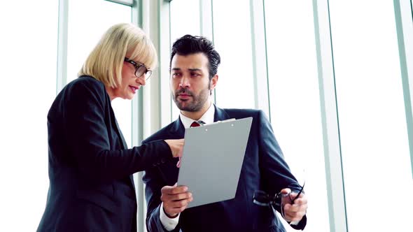 Two Business People Talk Project Strategy at Office