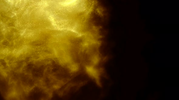 Golden Sand or Dust Creating Abstract Formations In the Form of the Sun on Black Background. Art