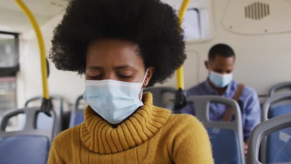 African american businesswoman with face mask sitting in bus