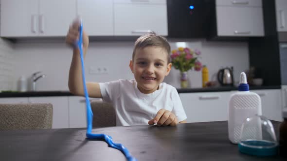 Smiling Boy Playing with Long Handmade Slime