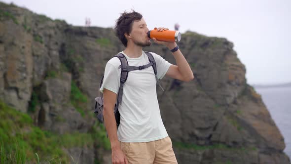 A Young Man on a Hike Among Rocks Near the Sea