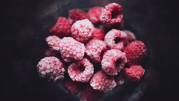 A Pile of Frozen Raspberries is Quickly Defrosted in a Glass