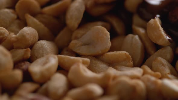 Pouring melted chocolate onto peanuts. Slow Motion. alt