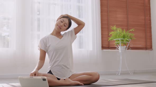 In the fitness studio, an Asian woman is studying online fitness training.