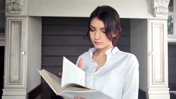 Concentrated Young Girl Reading Book Turning Paper Page Enjoying Weekend at Home