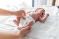 Newborn baby screaming while mother puts a diaper on the changing table - PhotoDune Item for Sale