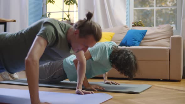 Two Young Men Doing Push-ups Exercise Working Out at Home.