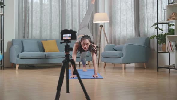 Trainer Female In Sports Clothes Speaking To Camera And Stretching While Recording Teaching Exercise