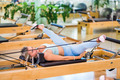 Woman stretching legs on pilates reformer - PhotoDune Item for Sale