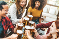 Happy multiethnic friends cheering beer glasses in brewery pub restaurant - PhotoDune Item for Sale