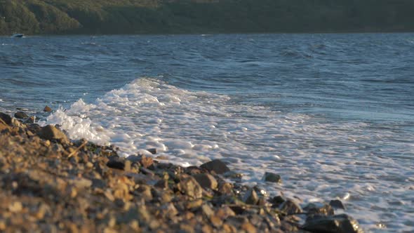 The Waves Crashing Against the Rock on the Sea Shore on the Sunset