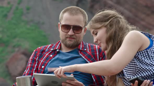 Couple Playing on Tablet on Camping Trip