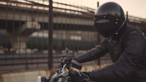 Young Attractive Man Motorcyclist with His Helmet and Custom Motorcycle on Street