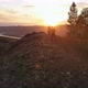 Aerial Shot of a Young Couple Running To the Top of a Mountain at Sunset - VideoHive Item for Sale