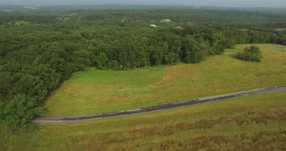 Aerial views of family bicycling along pastoral country roads.