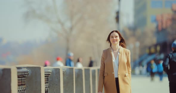 Young Brunette Woman Walks Down a City Street, the Girl Is Elegantly Dressed. Spring Walk