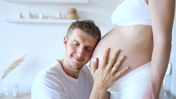 Happy Man Kissing Belly Of His Pregnant Wife