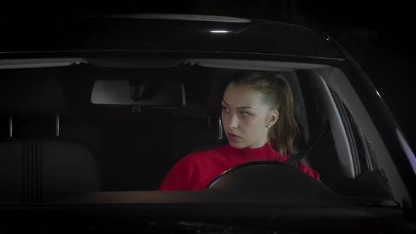 A Woman Driving a Car Sets Up a Rearview Mirror and Side Mirrors