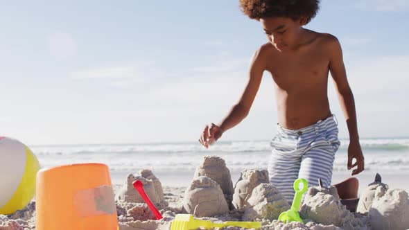 African american brother and sister playing with sand on the beach