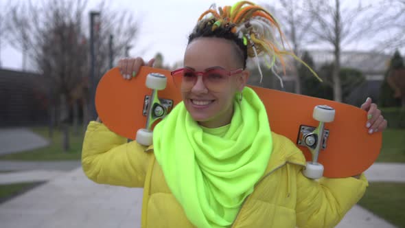 Young Happy Modern Teenage Woman with Skateboard