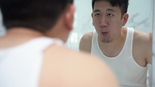 Asian Man Gargling with Mouthwash in Toilet