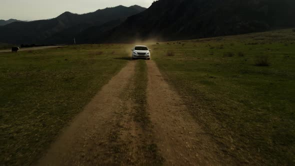 A White Car Moves Offroad in a Beautiful Mountain Landscape