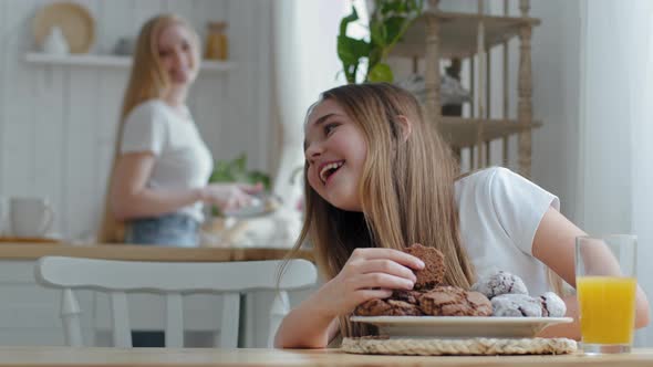 Cute Teenage Girl Child Daughter Sitting at Table in Kitchen at Home Breakfast in Morning Eating