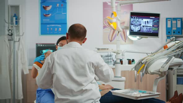 Dentist Drilling Woman Tooth in Dental Clinic