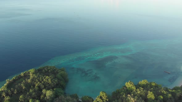 Aerial: flying over tropical Ai island white sand beach Banda Islands Indonesia