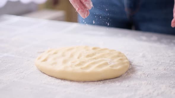 Apple Pie Preparation Series  Woman Pours Flour on a Dough to Roll It Out
