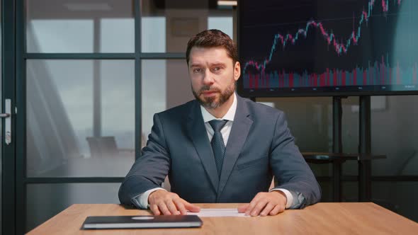 Mature man on video conference in office. Mature businessman cheering while chatting with colleagues