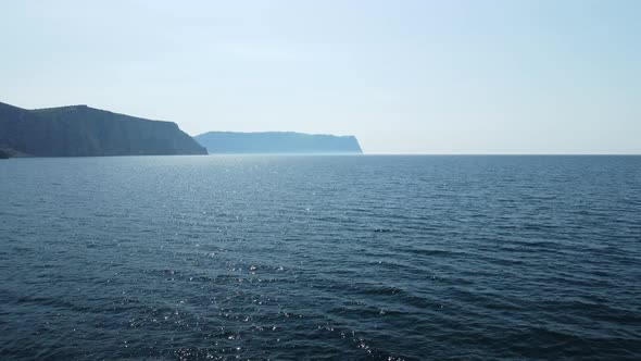 Aerial View From Above on Calm Azure Sea and Volcanic Rocky Shores