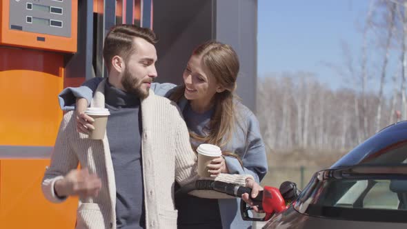 Woman Bringing Coffee to Husband at Gas Station