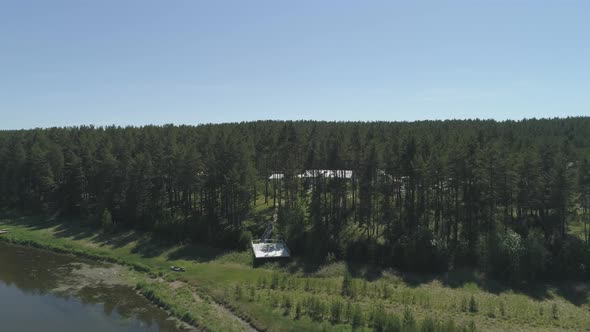 Aerial view of wedding arch on the pier by the river next to the forest 02