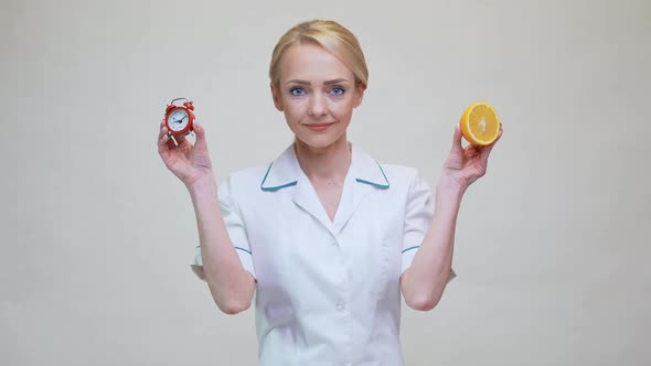 Nutritionist Doctor Healthy Lifestyle Concept - Holding Orange Fruit and Alarm Clock