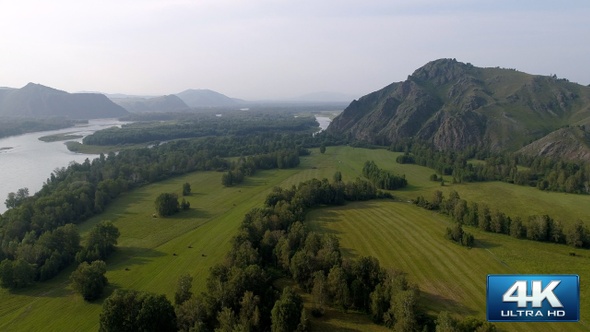 Flying over Green Steppe with River and  Mountains