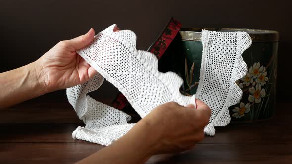 Woman is examining a beautiful vintage white lace ribbon