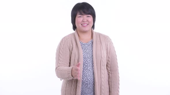 Happy Overweight Asian Woman Giving Handshake Ready for Winter