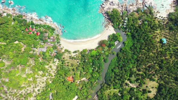 River flow through the jungle. Sandy secluded beach and hilled coast, Koh Phangan, Thailand