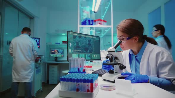 Team of Scientist Checking Virus Development Using Microscope