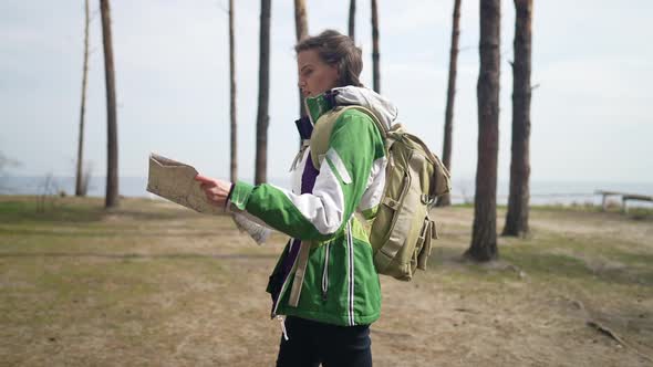 Side View Woman with Paper Map Walking in Slow Motion in Wilderness