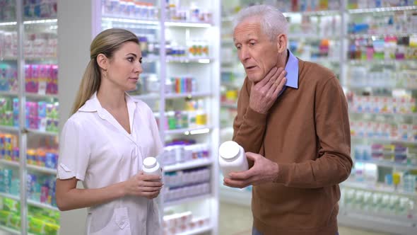 Nervous Senior Man Arguing with Pharmacist in Drugstore Yelling Gesturing Standing with Pill Bottle