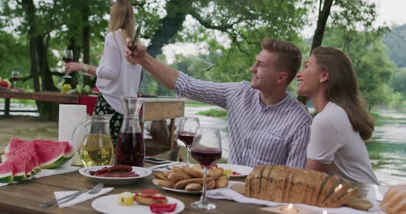 Young Happy Couple Taking Selfie While Having Picnic French Dinner Party Outdoor During Summer