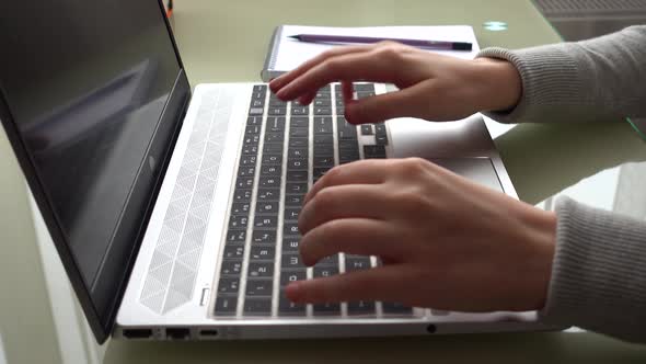 The girl working at home office hands on keyboard