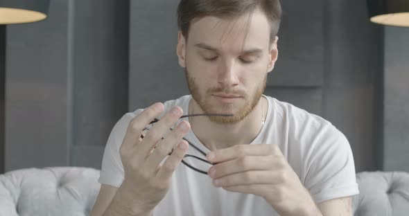 Close-up Portrait of Tired Caucasian Man Taking Off Eyeglasses and Rubbing Temples