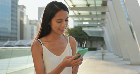 Woman using mobile phone in Hong Kong city 