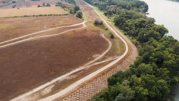 Sunny day above big meadow near Danube river. Aerial drone footage of nature around Danube river.