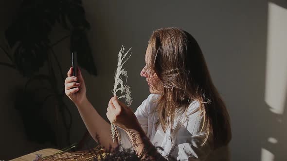 Woman with Fern Taking Selfie on Mobile Phone at Home